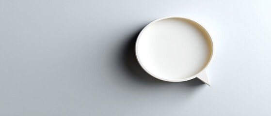 Minimalistic white speech bubble casting shadow on smooth gray surface with soft lighting and clean composition