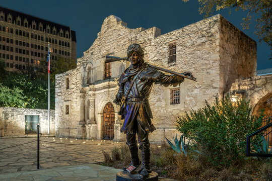 San Antonio TX, USA - December 4, 2025:  Night photo of The Alamo Mission in San Antonio Texas, with statue of Davy Crockett.
