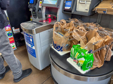  New Albany, Indiana USA December 10, 2025: A man using a U Scan  a Krogers grocery store in Indiana