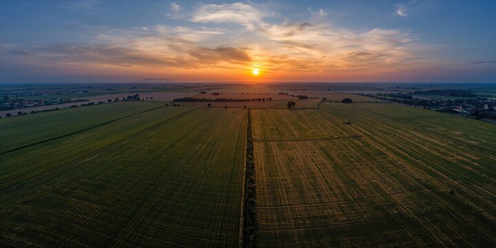 Aerial view of sunset over geometric agricultural fields in Ginosa, Italy, landscape preservation