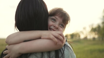 Child hugging parent in grassy field warm smile from daughter expresses love family bond as child hug parent amid nature tall grass gentle breeze joyful expression of affection and connection