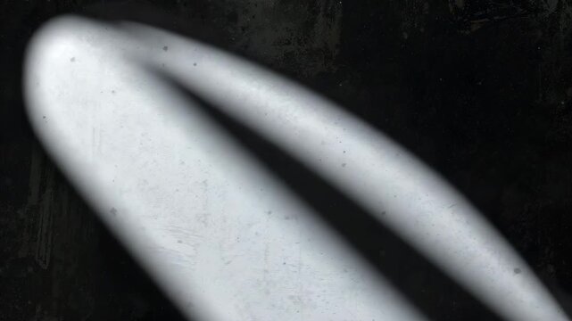 Abstract black background transitioning to a smooth gray surface with light reflections showcasing gradual movement and texture variations in a minimal monochrome setting