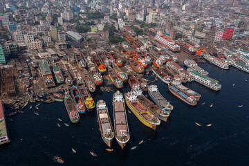 Aerial view of a dense gathering of colorful ships clustered along the Buriganga River's edge, contrasting with the urban skyline, Dhaka, Dhaka Division, Bangladesh.