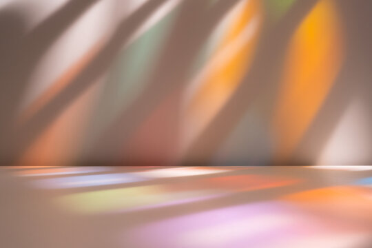 Stained glass light on wall and floor. Warm tones. Background with smooth abstract light reflections on wall. 