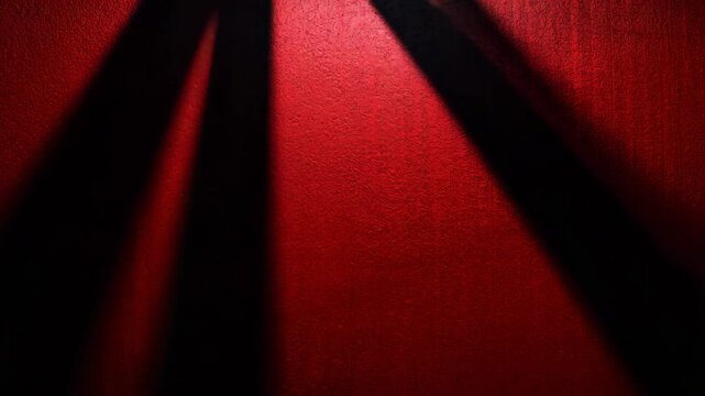 Slatted shadows moving across red textured wall cinematic background