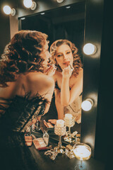 real person blonde hair retro lady looking into mirror painting lips with lipstick, gloss cosmetics. sexy woman burlesque show actress, preparing makeup. Flapper girl 20s roaring twenties old style