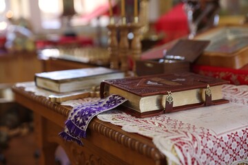 Holy Bible and other religious symbols on wooden table in church, closeup