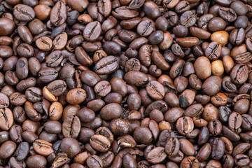 Closeup roasted coffee beans texture evokes morning warmth, piled in rustic heap, subtle oil sheen and rich brown tones, ideal for packaging, background and breakfast branding