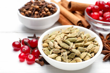 Different spices and cranberries for mulled wine on white wooden table, closeup