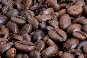 Coffee bean details, Closeup of roasted coffee beans, Sharp focus on shiny roasted coffee beans, Detailed view of glossy roasted coffee beans highlighting aroma and texture