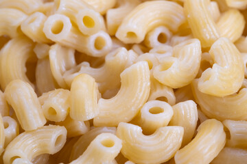 Beautiful pasta closeup, Shiny elbow macaroni detail, High contrast image of glossy pasta surfaces, Closeup photograph highlighting uniform smoothness of boiled elbow pasta