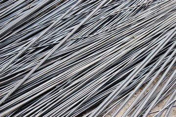 Obraz premium Stack of ribbed steel reinforcement bars (rebar), ready for building construction.