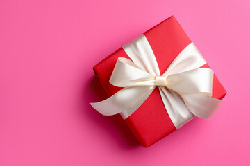 Beautiful gift on pink background, top view. Space for text
