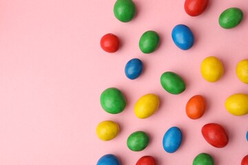 Delicious colorful candies on pink background, flat lay. Space for text