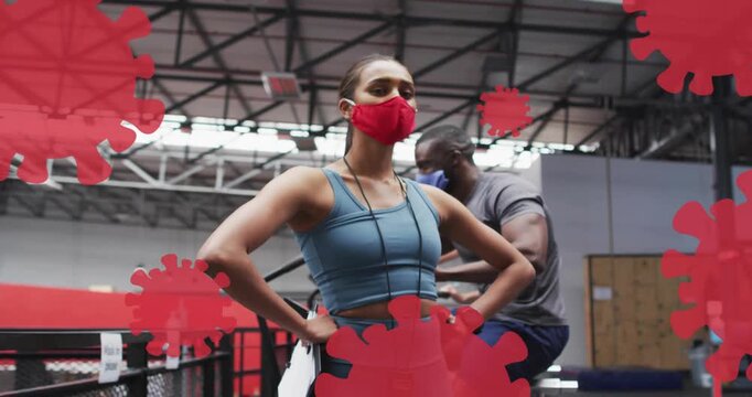 Woman hands-on-hips coaching, gym straps shifting revealing her while man rowing, virus overlaying