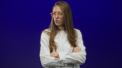 Woman scientist wearing lab coat and glasses with arms crossed in purple studio; frustration...