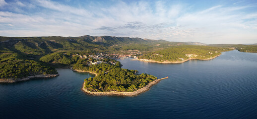 Aerial view of the tranquil harbor embracing the quaint town against a backdrop of verdant hills, Jelsa, Split-Dalmatia County, Croatia.