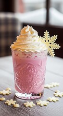 A tall glass of pink beverage topped with whipped cream and a snowflake decoration. Several snowflake-shaped cookies surround the drink