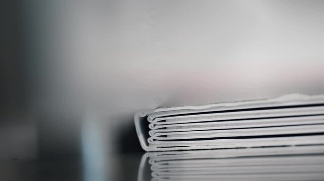 Close up of bound pages on binding press in printing plant production process