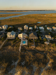 Aerial view of homes and dunes along the intracoastal waterway and ocean on Caswell Beach in Oak Island North Carolina