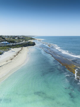 Aerial view of turquoise waters meet the sandy shore near 5 Brazier Road, contrasting with the rugged coastline, Yanchep, Western Australia, Australia.