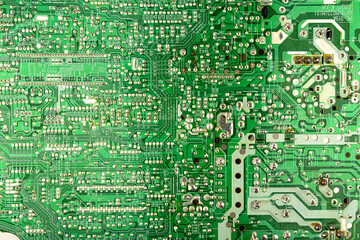 A close-up of a green printed circuit board from an electrical appliance or computer. Concept of electronics and microprocessor technology