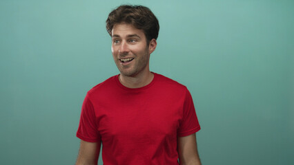 Young hispanic man with stubble in red tshirt smiling and looking to the right with head turned in...