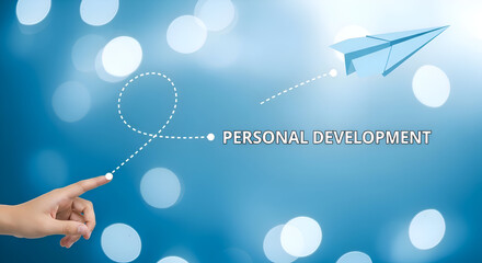 A hand guiding a dotted line leading to a paper airplane with personal development text on blue background with bokeh lights