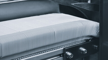 Elements of cardboard boxes are collected in stack. Conveyor line for the production of boxes. Machine cuts cardboard boxes from sheets of cardboard. Enterprise for  production package.