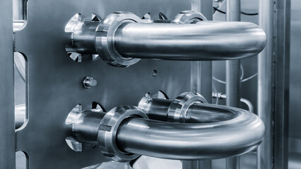Stainless steel pipes attached to stainless steel tank with industrial food production machine, industrial concept background