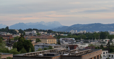 Fototapeta premium Bregenz city skyline with Lake Constance marina and alpine mountain backdrop at dusk