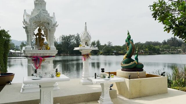 Traditional Thai spirit houses in Angsana in Puket, Thailand by a tranquil riverside setting