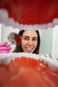 Confident dentist examining teeth from engaging patient viewpoint