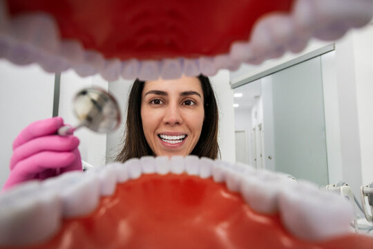 Friendly dentist performing checkup from immersive mouth perspective