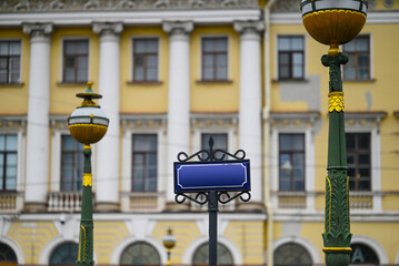 Naklejka premium Street sign and street lanterns on building background