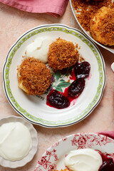 Traditional Austrian cottage cheese dumplings in breadcrumbs with plum compote and sour cream.