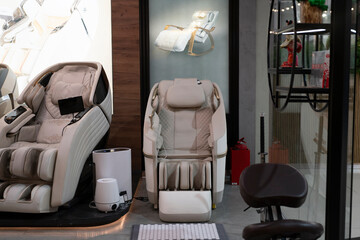 Two massage chairs sit in a store, showcasing different styles and designs available for customers