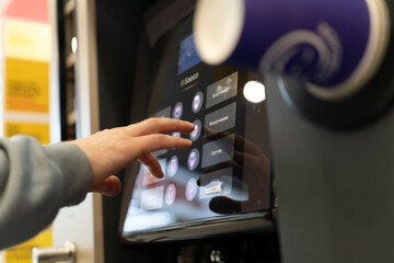 Person uses touch screen to select drink options at a self-service station in a fast food place
