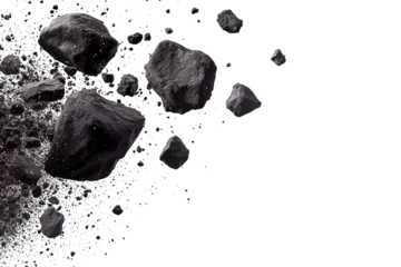 Coal fragments and dust particles in mid-air against a white background