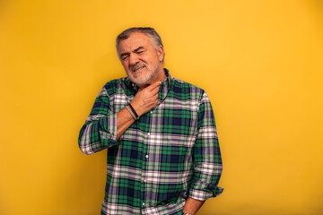 Senior man having sore throat touching neck