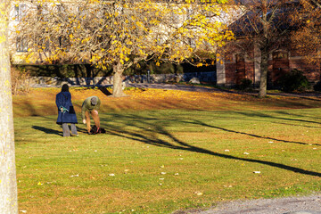 Fototapeta premium Couple Enjoying a Sunny Autumn Day in a Green City Park