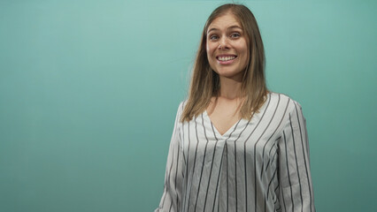 Obraz premium Young blonde woman face shifting from smile to sad frown in studio with teal wall; melancholy transition.