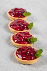 Vegan Cherry Round tartlets. With cream and mint. Light gray background