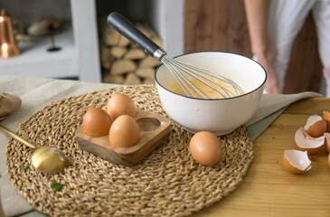 Woman prepare christmas dinner. Fresh egg and whipped omelette on rustic wooden table as a symbol of cooking process for holiday meal.