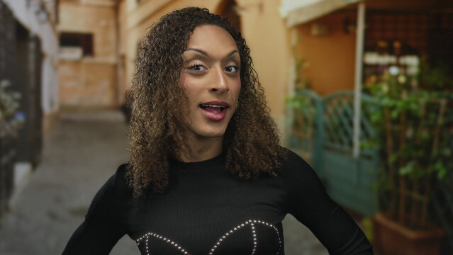 Transgender woman frowning with skeptical expression crosses arms on busy city street in daylight; denial.