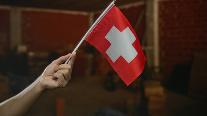 Man holding swiss flag indoors at construction site, symbolizing switzerland and its national pride in a home renovation setting.