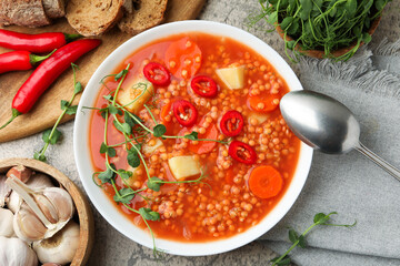 Delicious lentil soup with vegetables served on grey table, flat lay
