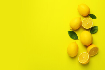 Fresh ripe lemons and leaves on yellow background, flat lay. Space for text