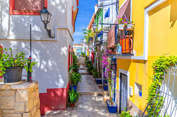 Obraz premium Alicante old town Barrio de Santa Cruz neighborhood with narrow street, typical white houses, Barri Vell Santa Creu Alacant, Casco Antiguo Santa Cruz quarter in Alicante city historic centre, Spain