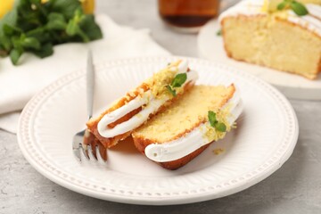 Delicious lemon cake with glaze, fresh fruit slices and mint served on table, closeup
